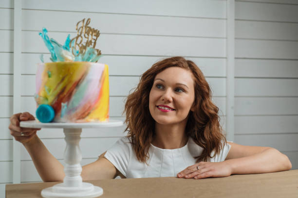 istock Beautiful female cake baker appraising her art 1182521492