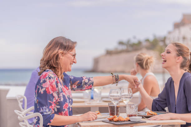 istock Beautiful young women holding hands while sitting sharing table on sunny day with beautiful background. 1182521681