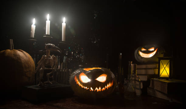 istock Halloween still-life background with different elements on dark toned foggy background. Selective focus 1182521748