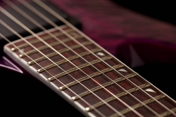istock Fretboard of modern electric guitar on black background. 1182522346