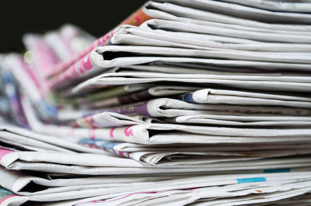 Newspapers folded and stacked on the table dark background. Closeup newspaper and selective focus image. Newspapers folded and stacked on the table dark background. Closeup newspaper and selective focus image. publisher photos stock pictures, royalty-free photos & images