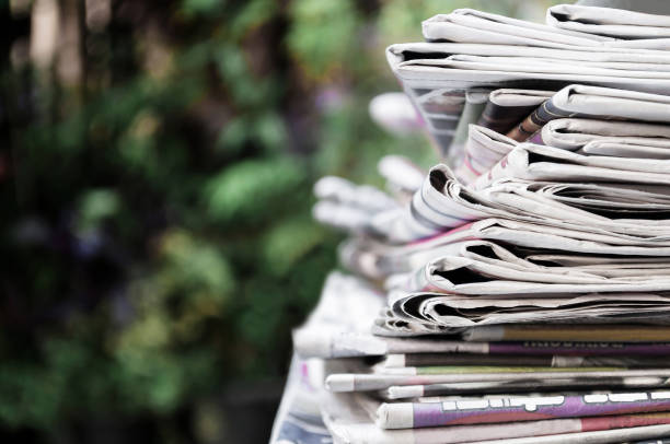 istock Newspapers folded and stacked on the table with garden. Closeup newspaper and selective focus image. Time to read concept. 1182523984
