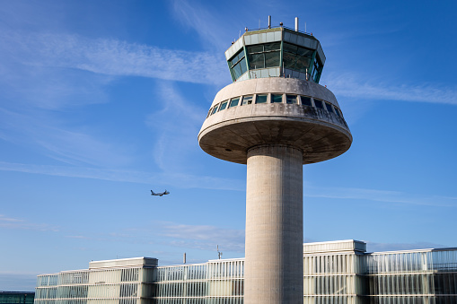 A Plane Flies Next To The Control Tower At Josep Tarradellas Barcelona el Prat Airport, Spain