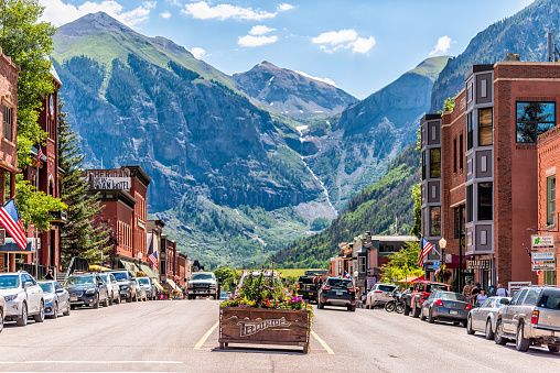 Telluride, USA - August 14, 2019: Small town village in Colorado with sign for city and flowers by historic architecture on main street mountain view