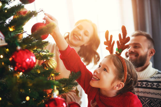 幸せな家族の母、父と子供の娘はクリスマスツリーを飾ります - 11992 ストックフォトと画像