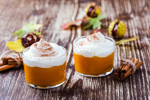 Autumn dessert, pumpkin mousse with whipped cream in glasses