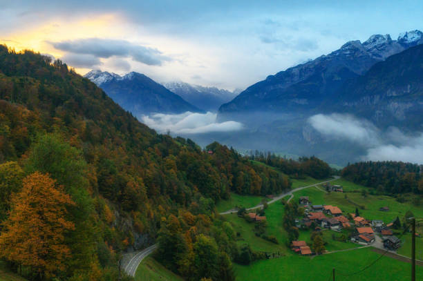 first light in the morning in swiss alps with villages first light in the morning in swiss alps with villages country road sky field cloudscape stock pictures, royalty-free photos & images