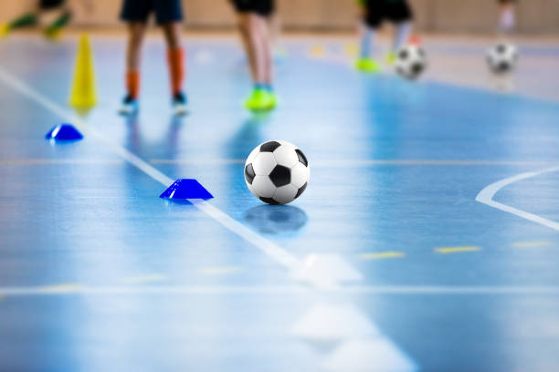 campo di allenamento di calcio a 5. giovani giocatori sportivi con palle in allenamento. primo tempo di palla di futsal. giocatore junior futsal in allenamento indoor. lezione di calcio invernale a scuola indoor futsal court - futsal indoors soccer ball soccer foto e immagini stock