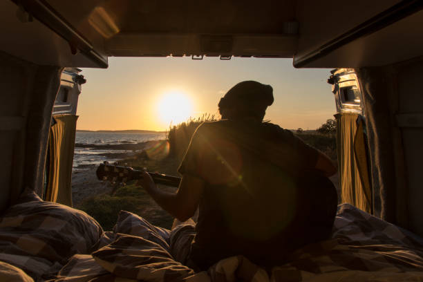 istock Man playing guitar in the evening sun 1182533903