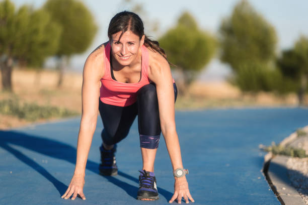 istock Athletic woman on running track getting ready to start run. 1182534630