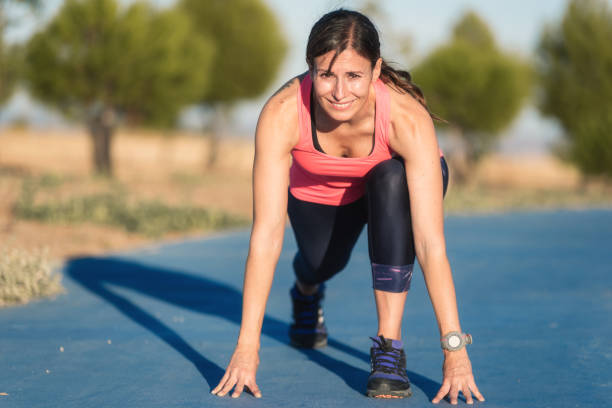 istock Athletic woman on running track getting ready to start run. 1182534660