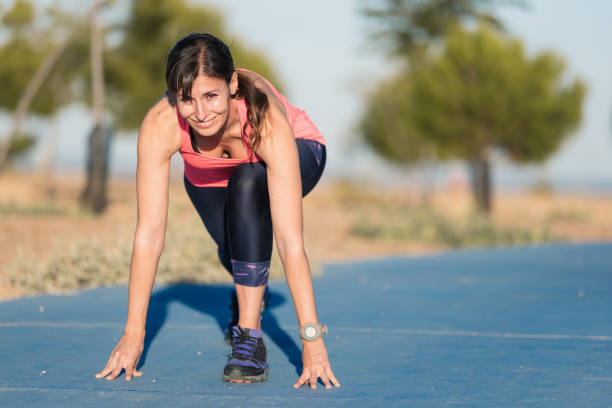istock Athletic woman on running track getting ready to start run. 1182534688