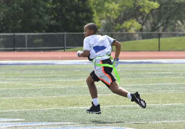 11 year old mixed race flag football player running on the field, summer
Downers Grove, Illinois  USA