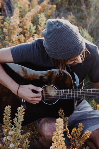 istock Man playing a guitar in the field 1182534907