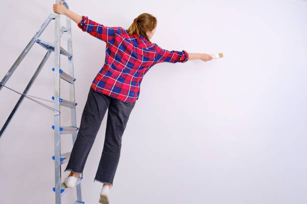 istock A woman paints the walls, falling from a stepladder. Problems with safety during repair work, copy space 1182535888