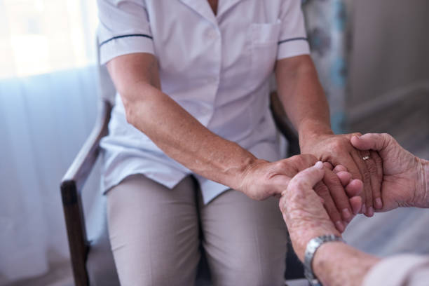 istock Nurse holding hands with a senior patient 1182538678