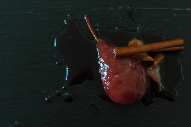 istock Drunken Pears with syrup, cinnamon sitck and lemon peel. Delicious dessert 1182542276