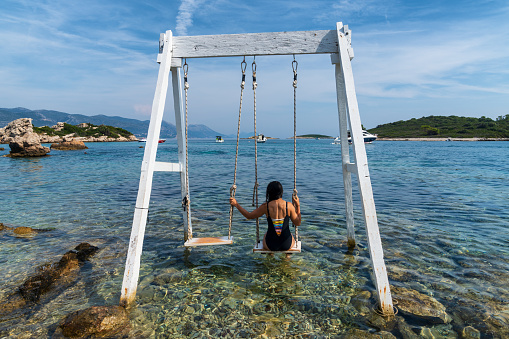 Tourism in Croatia - young adult tourist using a swing