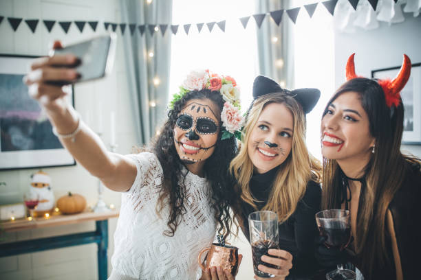 Halloween party selfie Group of Young people at home celebrating Halloween in costumes, they taking selfie carnival mask women party stock pictures, royalty-free photos & images