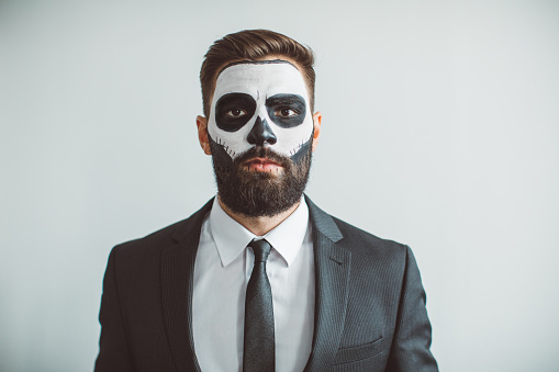 Young man celebrating Halloween with make up costume of skeleton in suit