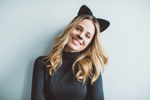 Young woman celebrating Halloween dressed-up in cat costume