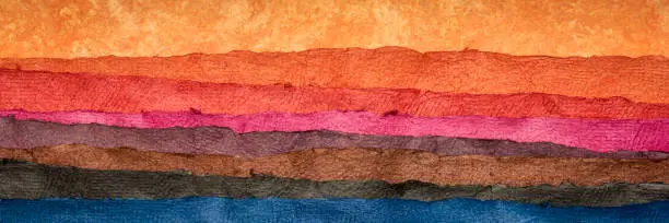abstract landscape created with sheets of textured colorful handmade paper, panoramic banner,