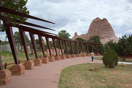 A lone senior woman take a photograph of the Navajo Code Talkers Honor Roll in the window rock city park that contains the world war II monument.