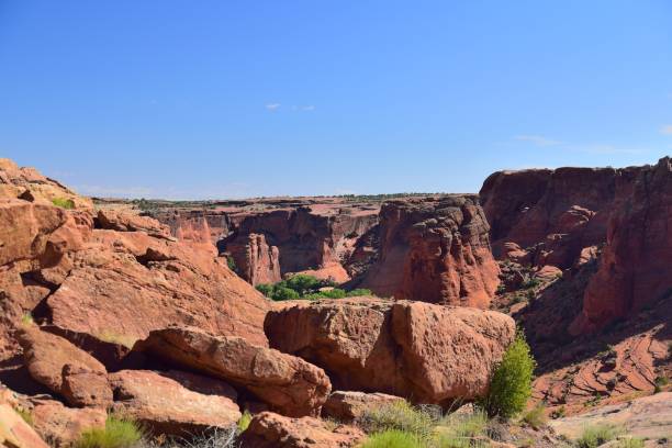 Canyon de Chelly Tunnel Overlook A view of canyon de chilly from the tunnel overlook on the south rim of the canyon with red rocks and blue sky on a summer day chinle arizona stock pictures, royalty-free photos & images