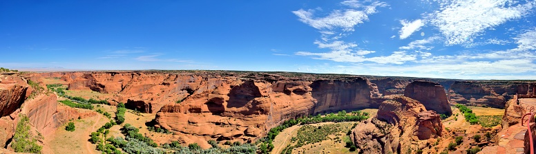A panoramic view of the canyon de chelly floor with the chinle dry creaked and cottonwood trees winding through the valley
