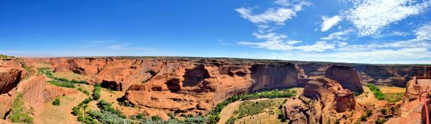 White House Overlook Canyon de Chelly A panoramic view of the canyon de chelly floor with the chinle dry creaked and cottonwood trees winding through the valley chinle arizona stock pictures, royalty-free photos & images