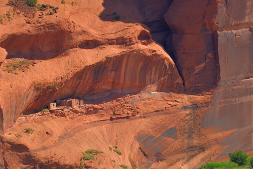 Looking on the far side of Canyon de Chelly, cliff dwellings of indigenous Americans from ancient times line the face of the canyon wall