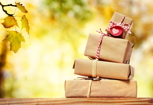 istock Stack of gift boxes with an autumn sky and foliage 1182560717