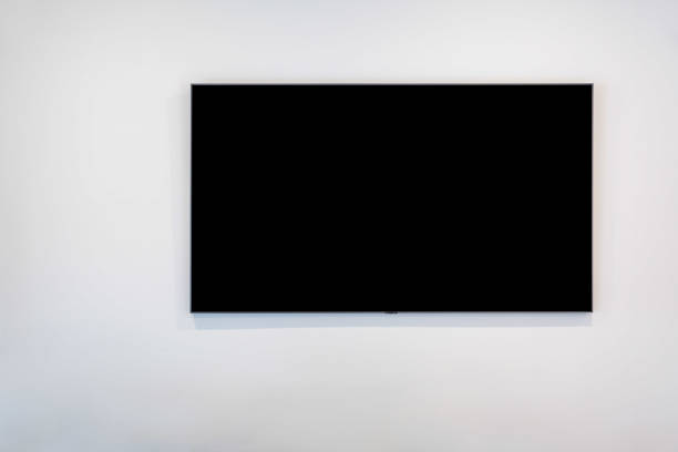 istock Black flat screen TV on white wall with copy space 1182561717