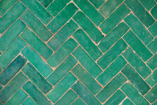 Green ceramic floor tile with herringbone pattern in Marrakesh riad