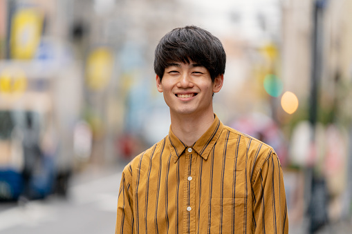 Portrait of a confident young man outdoors on the street. Tokyo, Japan.