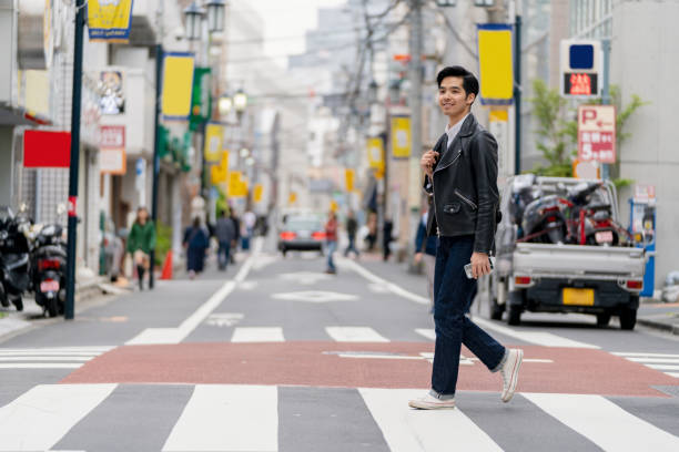 istock Confident young man crossing the road in Japan 1182564536