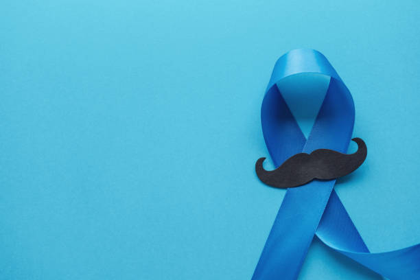 Light blue ribbons with mustache on blue background , Prostate Cancer Awareness, Movember Men health awareness,International Men's Day stock photo