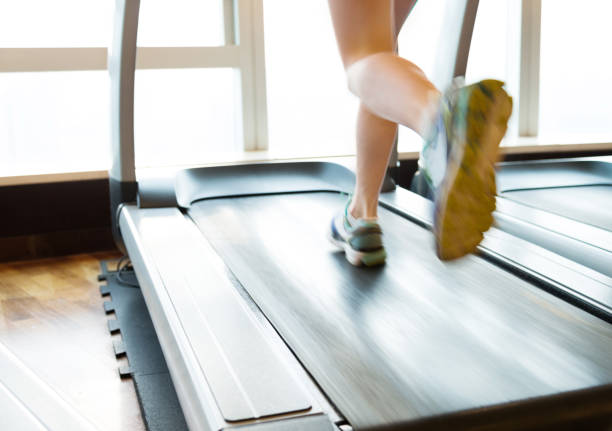 Cropped image of people jogging on treadmills at the gym