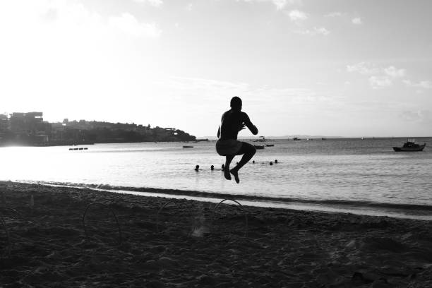 Salvador, Bahia, Brazil Boys and girls having fun jumping off a bridge in Ribeira on a beautiful evening in Salvador Ba. NOTE: The bridge was demolished in June 04/2019