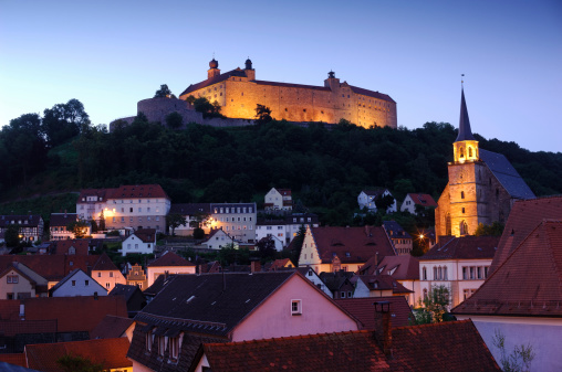 The medieval city center of Kulmbach with the overlooking Plassenburg at dusk. 