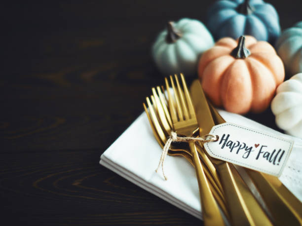 istock Thanksgiving Table Setting Background with Pumpkins and Gold Cutlery 1182573689