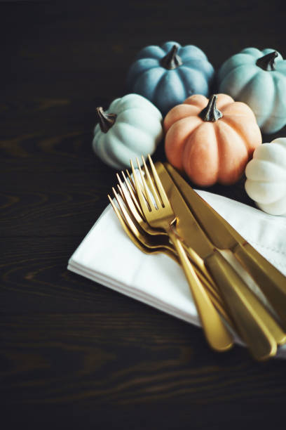 istock Thanksgiving Table Setting Background with Pumpkins and Gold Cutlery 1182573711