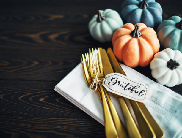 istock Thanksgiving Table Setting Background with Pumpkins and Gold Cutlery 1182573723