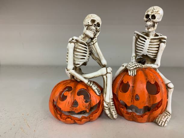 istock Halloween celebration, Funny two Human skeleton sitting on pumpkin. 1182573969