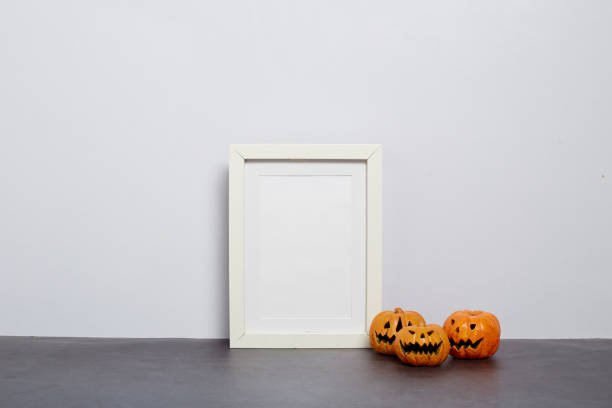 istock Mock up black frame with Jack o Lantern and pumpkin decor on a shelf or desk. 2020 Halloween concept 1182575918