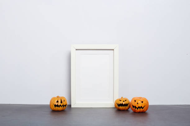 istock Mock up black frame with Jack o Lantern and pumpkin decor on a shelf or desk. 2020 Halloween concept 1182575923