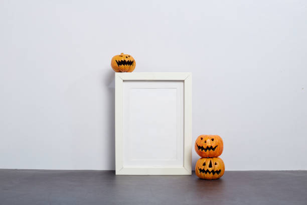istock Mock up black frame with Jack o Lantern and pumpkin decor on a shelf or desk. 2020 Halloween concept 1182575933