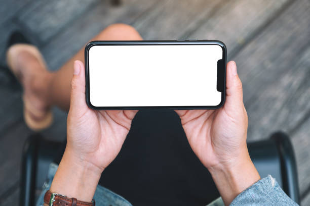 istock a woman holding a black mobile phone with blank white desktop screen 1182576349