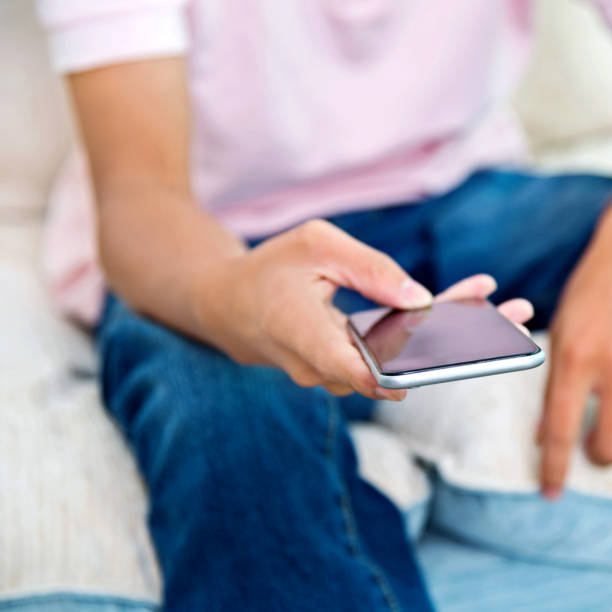 istock Man hand holding a smartphone at home 1182577381