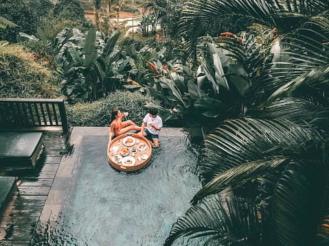 Floating breakfast in infinity pool on paradise swimming pool, morning in the tropical resort Bali, Indonesia